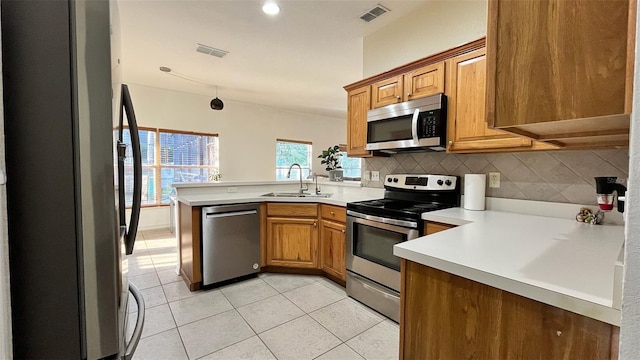 3901 Ballinore Pl, Gotha, FL 34734 - kitchen with appliances with stainless steel finishes, a sink, a peninsula, backsplash, and light tile patterned floors