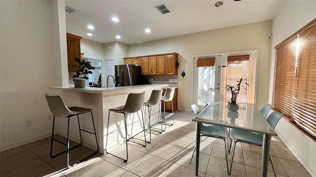 3901 Ballinore Pl, Gotha, FL 34734 - kitchen with fridge with ice dispenser, a breakfast bar area, a sink, recessed lighting, and light countertops