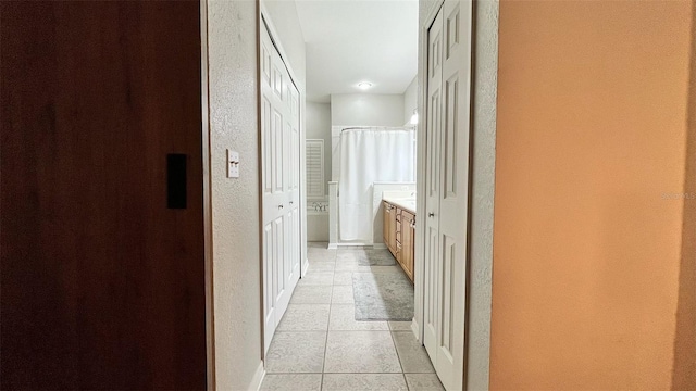 3901 Ballinore Pl, Gotha, FL 34734 - corridor featuring a textured wall, light tile patterned flooring, and baseboards