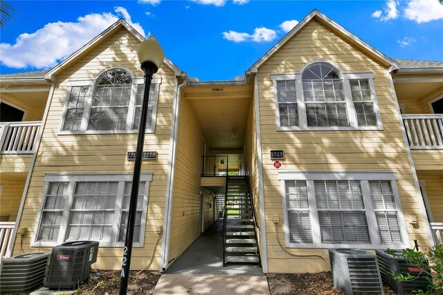 1025 S Hiawassee Rd Unit 2225, Orlando, FL 32835 - view of front facade featuring stairs, central AC unit, and a balcony