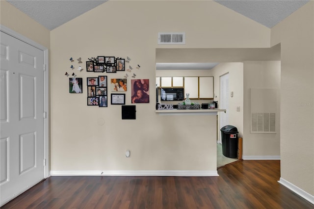 1025 S Hiawassee Rd Unit 2225, Orlando, FL 32835 - kitchen featuring lofted ceiling, black microwave, dark wood finished floors, baseboards, and white cabinets