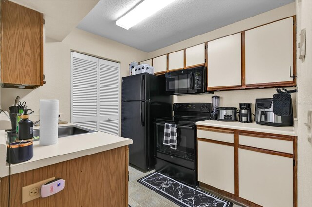 1025 S Hiawassee Rd Unit 2225, Orlando, FL 32835 - kitchen featuring black appliances, light countertops, white cabinets, a sink, and a textured ceiling