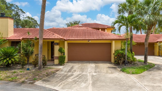 5015 Nassau Cir Unit 4, Orlando, FL 32808 - view of front of home featuring a garage, stucco siding, driveway, and a tile roof