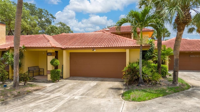 5015 Nassau Cir Unit 4, Orlando, FL 32808 - view of front facade with an attached garage, a tiled roof, stucco siding, and driveway
