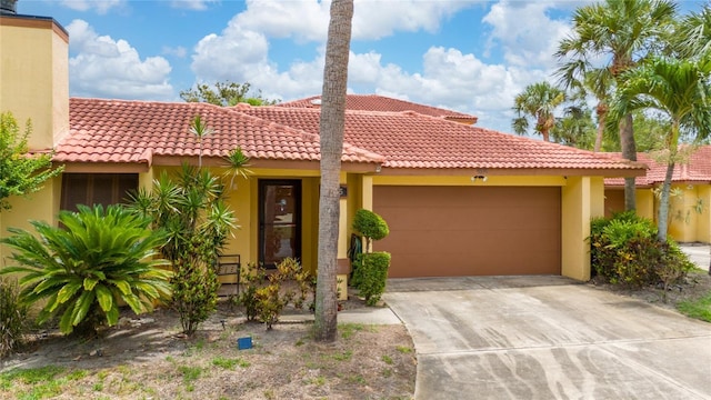 5015 Nassau Cir Unit 4, Orlando, FL 32808 - view of front of property featuring an attached garage, stucco siding, concrete driveway, and a tile roof