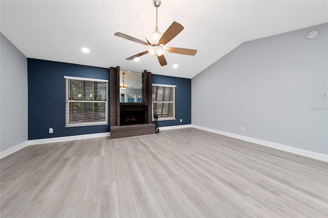 5015 Nassau Cir Unit 4, Orlando, FL 32808 - unfurnished living room featuring ceiling fan, a brick fireplace, lofted ceiling, light wood-style flooring, and baseboards