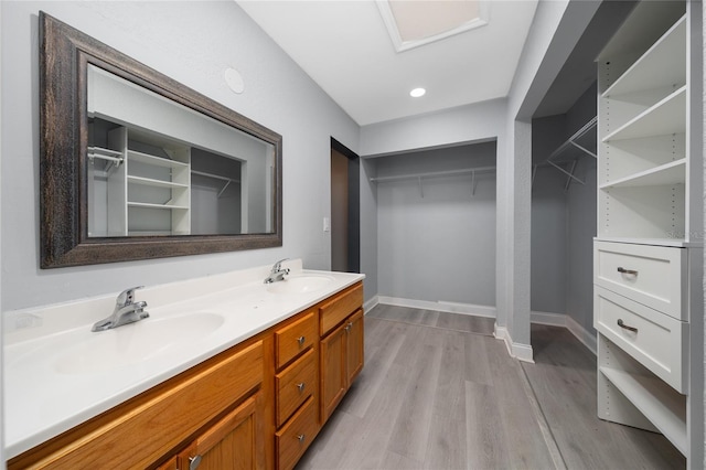 5015 Nassau Cir Unit 4, Orlando, FL 32808 - bathroom featuring double vanity, wood finished floors, baseboards, a spacious closet, and recessed lighting