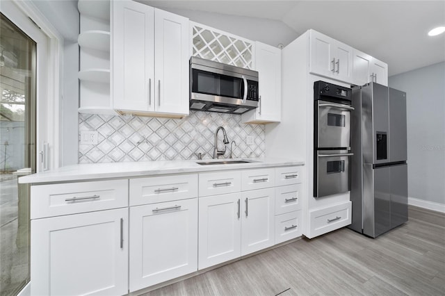 5015 Nassau Cir Unit 4, Orlando, FL 32808 - kitchen with appliances with stainless steel finishes, a sink, open shelves, white cabinets, and light wood finished floors