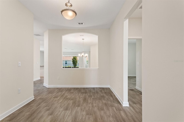 1101 Downswing Pl, Davenport, FL 33896 - empty room featuring wood finished floors, a chandelier, baseboards, and arched walkways