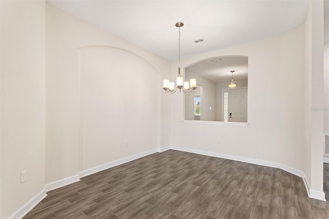 1101 Downswing Pl, Davenport, FL 33896 - empty room featuring dark wood finished floors, arched walkways, baseboards, and a chandelier