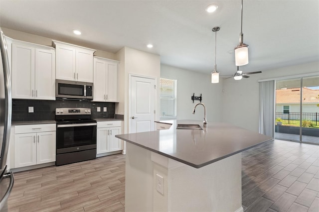 1101 Downswing Pl, Davenport, FL 33896 - kitchen with appliances with stainless steel finishes, a sink, light wood-style floors, tasteful backsplash, and recessed lighting