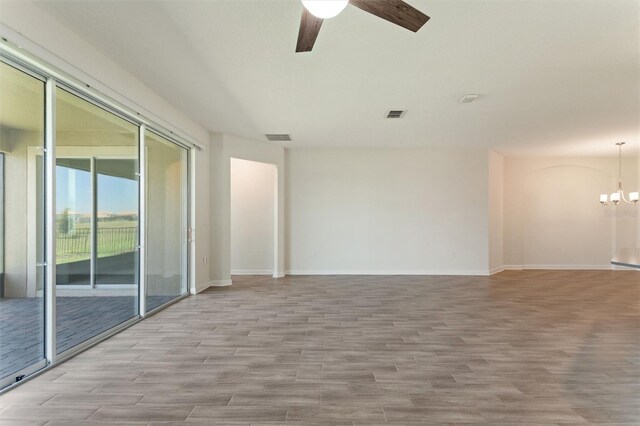 1101 Downswing Pl, Davenport, FL 33896 - empty room with wood finished floors, a ceiling fan, a chandelier, and baseboards
