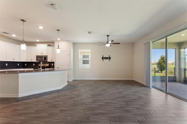 1101 Downswing Pl, Davenport, FL 33896 - kitchen with appliances with stainless steel finishes, baseboards, decorative backsplash, ceiling fan, and open floor plan