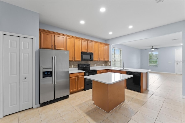 13636 Beauregard Pl, Orlando, FL 32837 - kitchen featuring black appliances, a sink, a peninsula, light countertops, and backsplash