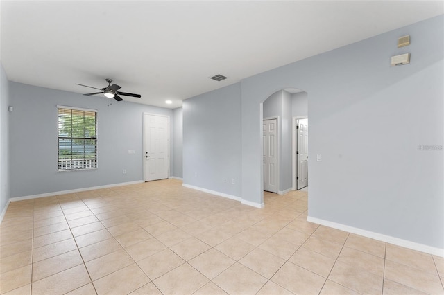 13636 Beauregard Pl, Orlando, FL 32837 - unfurnished room featuring arched walkways, a ceiling fan, light tile patterned floors, and baseboards