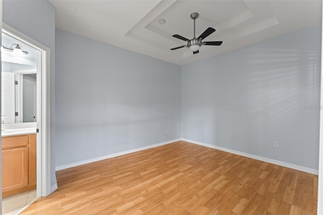13636 Beauregard Pl, Orlando, FL 32837 - unfurnished room featuring a tray ceiling, light wood finished floors, baseboards, and ceiling fan