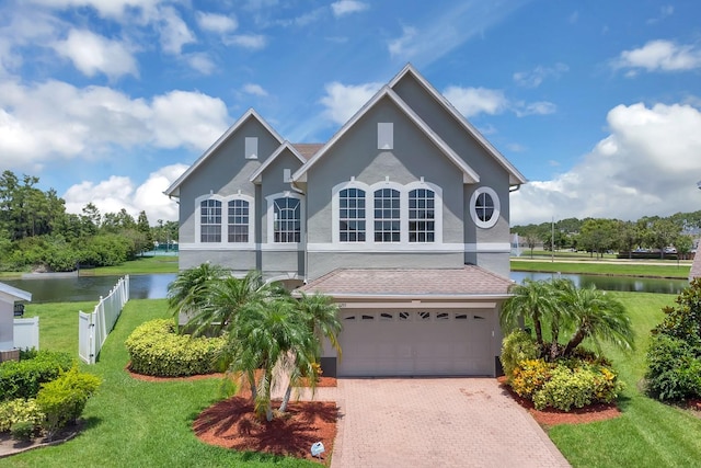 2255 Stone Lake Ct, Orlando, FL 32824 - traditional-style home featuring a water view, stucco siding, a garage, and decorative driveway