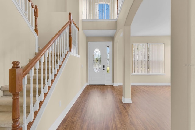 2255 Stone Lake Ct, Orlando, FL 32824 - foyer featuring wood finished floors, arched walkways, stairs, and a high ceiling