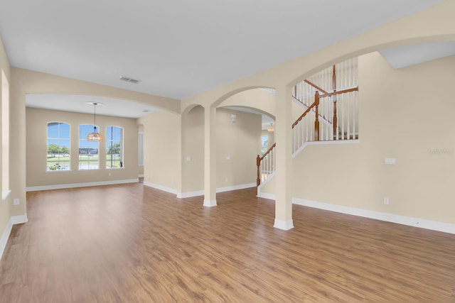 2255 Stone Lake Ct, Orlando, FL 32824 - unfurnished living room featuring wood finished floors, stairs, and arched walkways