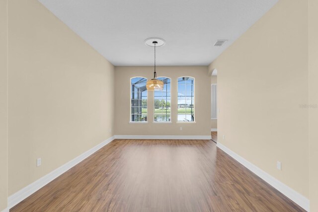2255 Stone Lake Ct, Orlando, FL 32824 - spare room featuring wood finished floors, arched walkways, and a chandelier