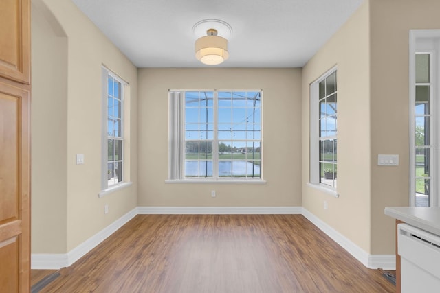 2255 Stone Lake Ct, Orlando, FL 32824 - unfurnished dining area featuring wood finished floors, a water view, and arched walkways
