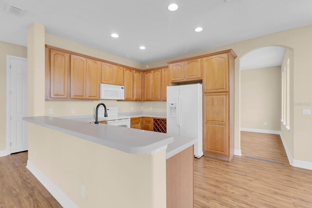 2255 Stone Lake Ct, Orlando, FL 32824 - kitchen featuring white appliances, arched walkways, light wood finished floors, recessed lighting, and light countertops