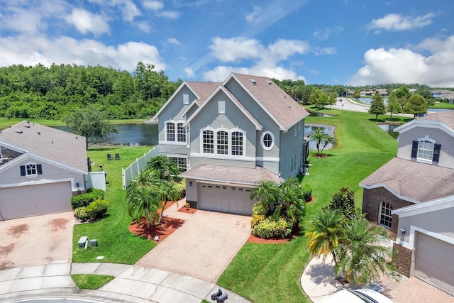 2255 Stone Lake Ct, Orlando, FL 32824 - traditional home featuring decorative driveway, stucco siding, a water view, a garage, and a front yard