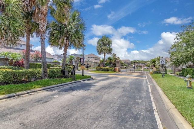 2255 Stone Lake Ct, Orlando, FL 32824 - view of asphalt street featuring traffic signs, a gate, curbs, and a gated entry