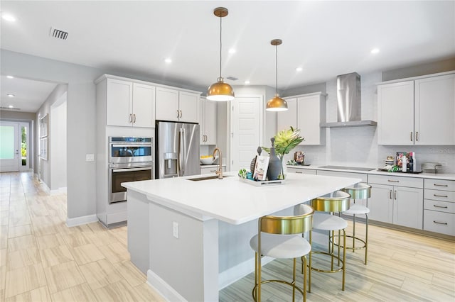 217 Thornberry Way, Palm Coast, FL 32164 - kitchen featuring wall chimney exhaust hood, a sink, stainless steel appliances, a kitchen island with sink, and light countertops
