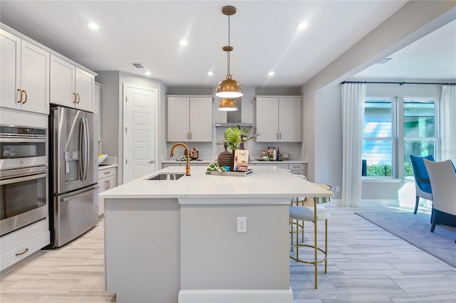 230 Thornberry Way, Palm Coast, FL 32164 - kitchen featuring stainless steel appliances, a sink, a breakfast bar, an island with sink, and light countertops