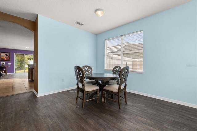 326 Highland Meadows Ave, Davenport, FL 33837 - dining area with arched walkways, wood finished floors, and baseboards