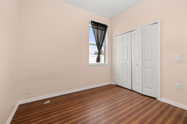 326 Highland Meadows Ave, Davenport, FL 33837 - unfurnished bedroom with baseboards, dark wood-type flooring, and a closet