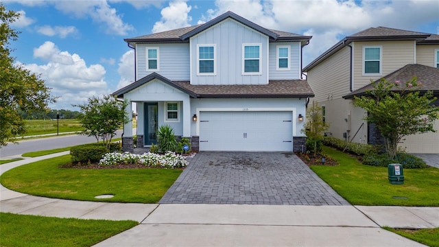 1335 Greenfield Loop, Kissimmee, FL 34747 - view of front of property with board and batten siding, decorative driveway, an attached garage, and a front yard