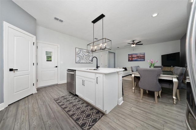 1335 Greenfield Loop, Kissimmee, FL 34747 - kitchen with a sink, dishwasher, open floor plan, light wood-style floors, and light countertops