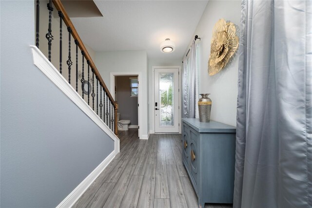 1335 Greenfield Loop, Kissimmee, FL 34747 - entryway with baseboards, light wood finished floors, and stairway