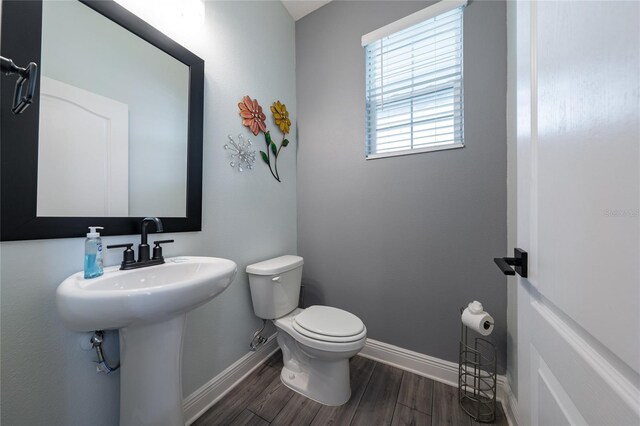 1335 Greenfield Loop, Kissimmee, FL 34747 - bathroom featuring toilet, baseboards, and wood finished floors
