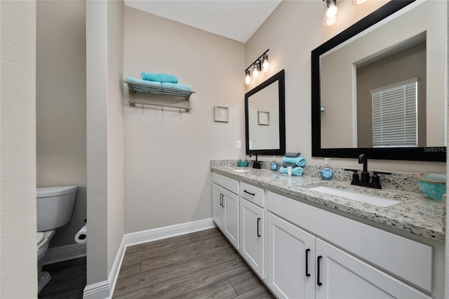 1335 Greenfield Loop, Kissimmee, FL 34747 - bathroom with toilet, double vanity, wood finished floors, and baseboards