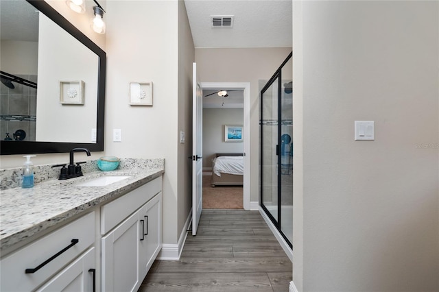 1335 Greenfield Loop, Kissimmee, FL 34747 - ensuite bathroom with vanity, wood finished floors, baseboards, a stall shower, and ceiling fan