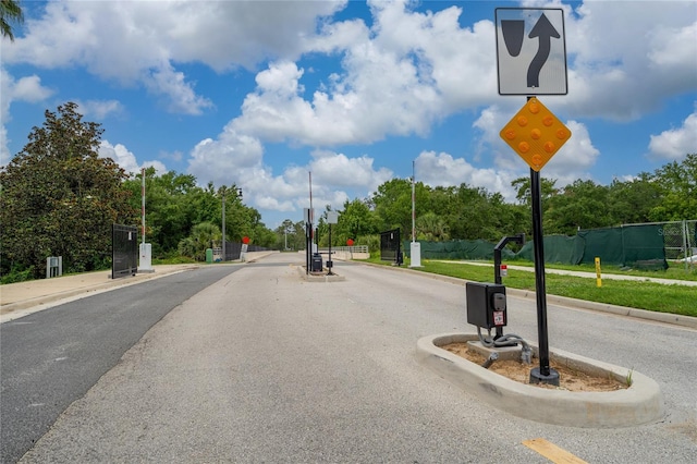1335 Greenfield Loop, Kissimmee, FL 34747 - view of asphalt road with traffic signs, curbs, sidewalks, and a gated entry