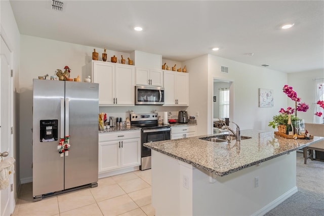 1102 Tupelo Trl, Haines City, FL 33844 - kitchen with appliances with stainless steel finishes, white cabinets, light stone counters, an island with sink, and recessed lighting