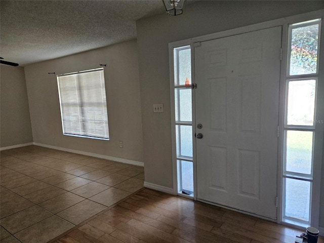 2805 Rodeo Dr, Kissimmee, FL 34746 - foyer with baseboards, healthy amount of natural light, a textured ceiling, and wood finished floors