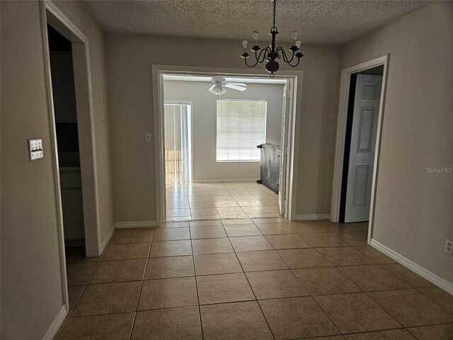 2805 Rodeo Dr, Kissimmee, FL 34746 - corridor with a chandelier, a textured ceiling, tile patterned floors, and baseboards