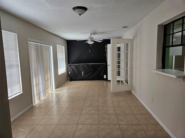 2805 Rodeo Dr, Kissimmee, FL 34746 - tiled spare room with ceiling fan, a textured ceiling, and baseboards