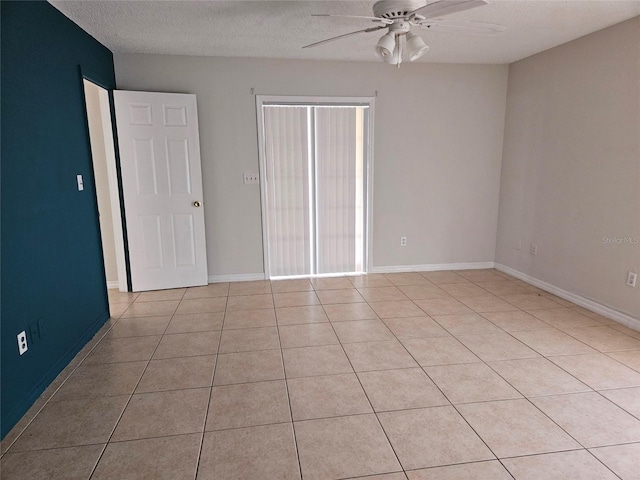 2805 Rodeo Dr, Kissimmee, FL 34746 - empty room featuring a ceiling fan, a textured ceiling, light tile patterned floors, and baseboards