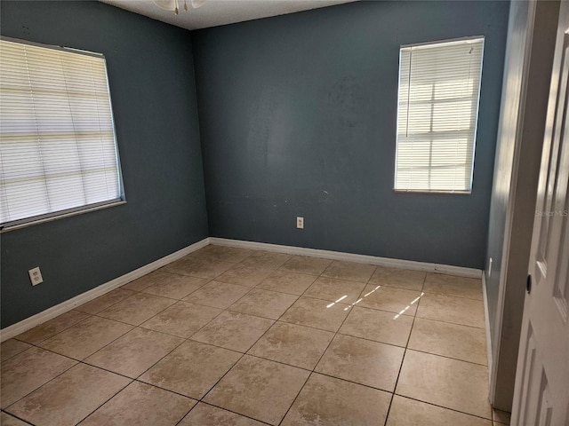 2805 Rodeo Dr, Kissimmee, FL 34746 - empty room featuring healthy amount of natural light, light tile patterned flooring, a ceiling fan, and baseboards