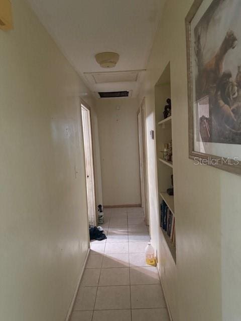 4339 Solomon Dr, Orlando, FL 32811 - hallway with light tile patterned floors, built in features, and attic access