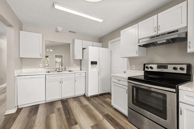 2146 Fish Eagle St, Clermont, FL 34714 - kitchen with white appliances, under cabinet range hood, a sink, and white cabinets