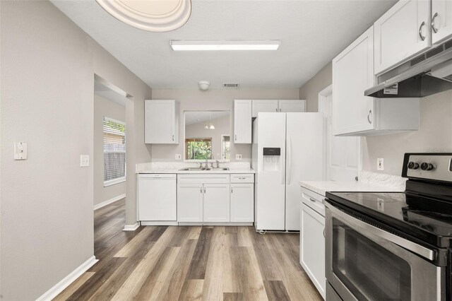 2146 Fish Eagle St, Clermont, FL 34714 - kitchen with white appliances, under cabinet range hood, a sink, light countertops, and white cabinetry