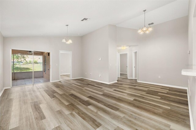 2146 Fish Eagle St, Clermont, FL 34714 - unfurnished living room featuring a chandelier, high vaulted ceiling, light wood-style flooring, and baseboards