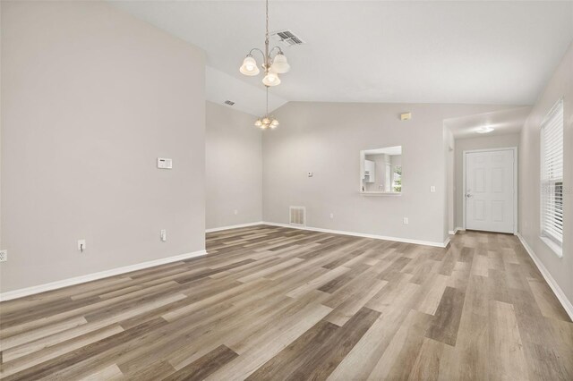 2146 Fish Eagle St, Clermont, FL 34714 - unfurnished living room with lofted ceiling, a chandelier, light wood-style floors, and baseboards